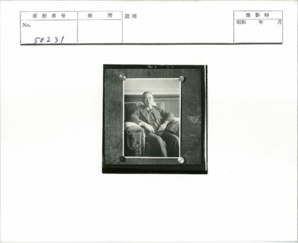 西装男子坐木板扶手椅.jpg