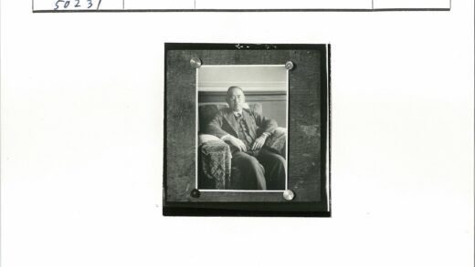 西装男子坐木板扶手椅.jpg