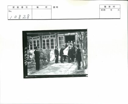 西装男子抬棺走出古典建筑.jpg