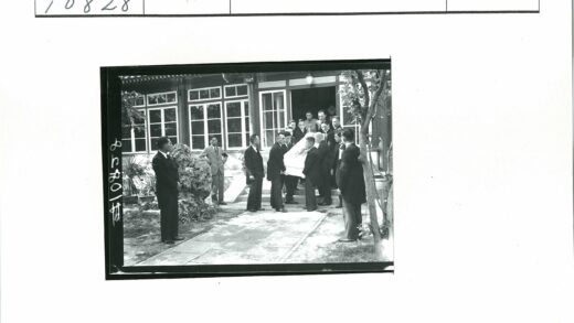 西装男子抬棺走出古典建筑.jpg