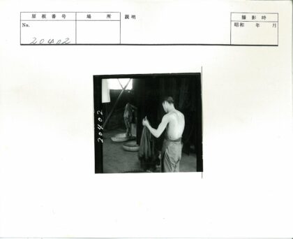 赤膊男子室内整理深色布料.jpg