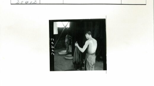 赤膊男子室内整理深色布料.jpg