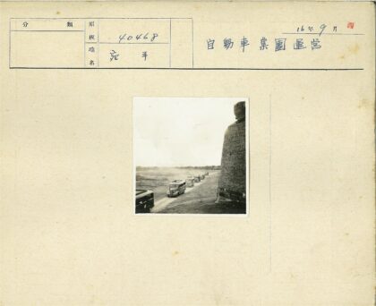 车队行驶于砖砌建筑旁土路.jpg