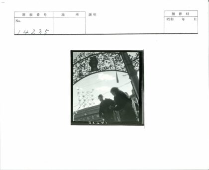 金属拱门下行人与建筑背景.jpg