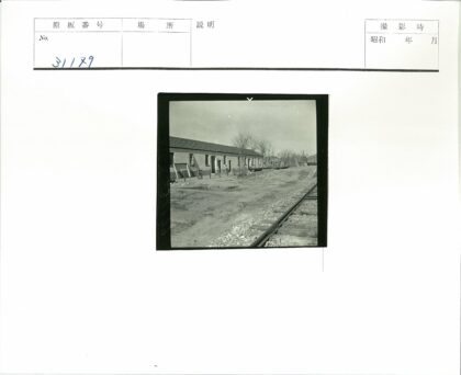 铁路旁单层斜顶建筑与枯树.jpg
