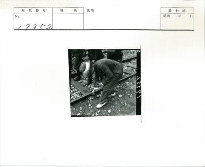 铁路旁检查轨道的男子与旁观者.jpg
