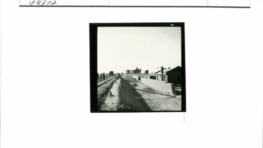 铁路旁行人走过砖墙建筑.jpg
