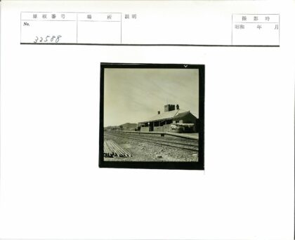 铁路沿线砖砌建筑与山脉背景.jpg