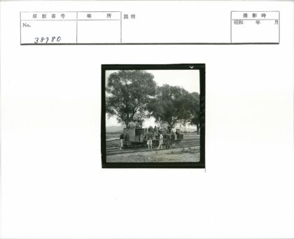 铁轨旁大树下的人群与火车车厢.jpg