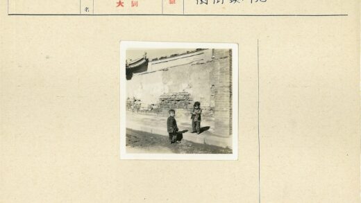 阳光下的两个孩子与旧砖墙.jpg