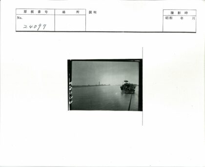 阴天水面上盖布船与远塔.jpg