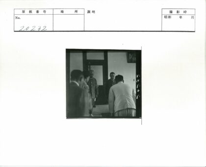 鞠躬男子在挂画房间内.jpg