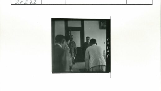 鞠躬男子在挂画房间内.jpg