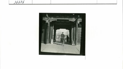 骑行者穿越雕花大门与狮子雕像.jpg