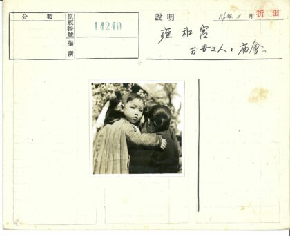 黑发成人抱穿图案夹克小孩树下.jpg