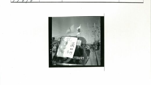 黑色轿车挂白牌旗帜街景.jpg