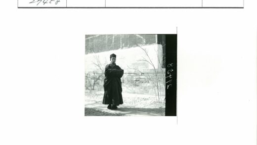 黑袍人立于石径枯枝墙前.jpg