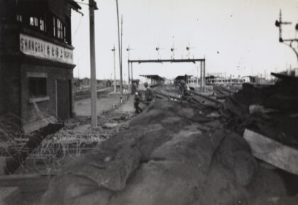 【jpg清晰版】1937年10月上海北火车站日军士兵抬着担架上的伤兵.jpg