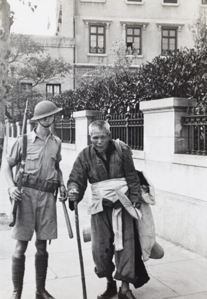 【jpg清晰版】1937年一名英国士兵与一位盲人难民在上海英国领事馆外.jpg