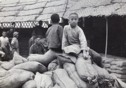 【jpg清晰版】1937年上海两名男孩坐在沙袋上英军士兵正在修筑防御工事.jpg