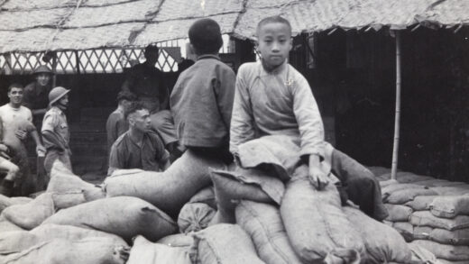 【jpg清晰版】1937年上海两名男孩坐在沙袋上英军士兵正在修筑防御工事.jpg