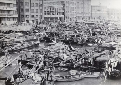 【jpg清晰版】1937年上海苏州河上一名上海市警察乘坐水上出租车穿梭于驳船和舢板之间.jpg
