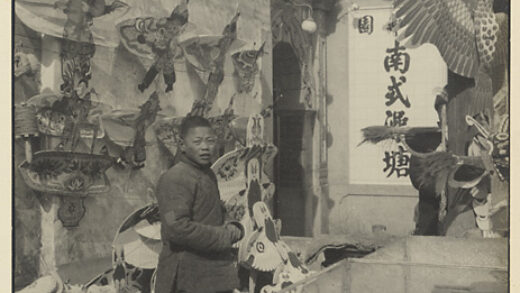 【jpg清晰版】卖风筝的男孩站在带题字的建筑旁.jpg