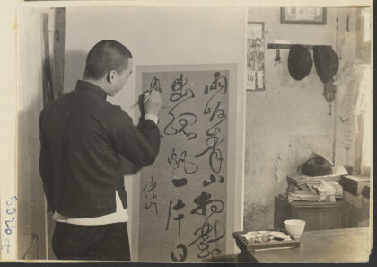 【jpg清晰版】卷轴装裱店内部展示男子修复悬挂在干燥板上的卷轴画.jpg