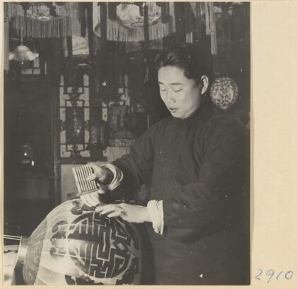 【jpg清晰版】男子在灯笼制作店中将字符粘贴在灯笼上.jpg