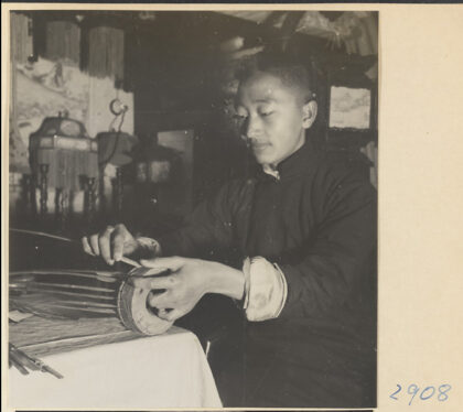 【jpg清晰版】男子在灯笼制作店中将骨架固定在灯笼底座上.jpg