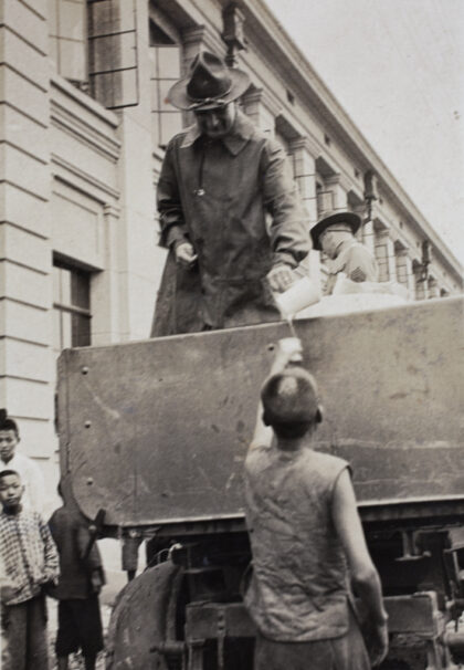 【jpg清晰版】1925年美国公司上海义勇团在上海华兴路电车棚附近分发大米配给.jpg
