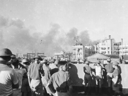 【jpg清晰版】1937年8月士兵站在一栋建筑的屋顶上烟雾弥漫上海上空.jpg