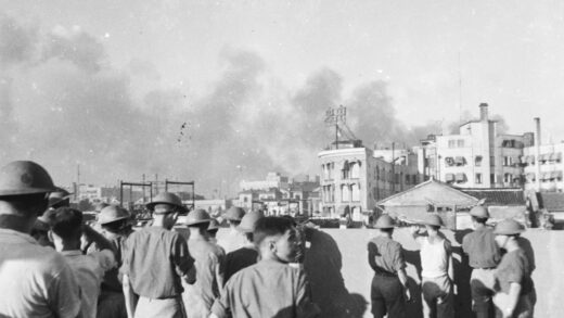 【jpg清晰版】1937年8月士兵站在一栋建筑的屋顶上烟雾弥漫上海上空.jpg