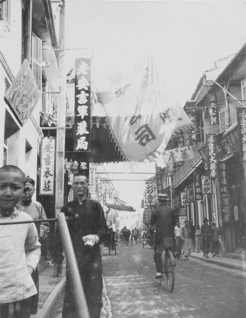 【JPG清晰版】购物街内含三家药店戴船夫帽的骑车人